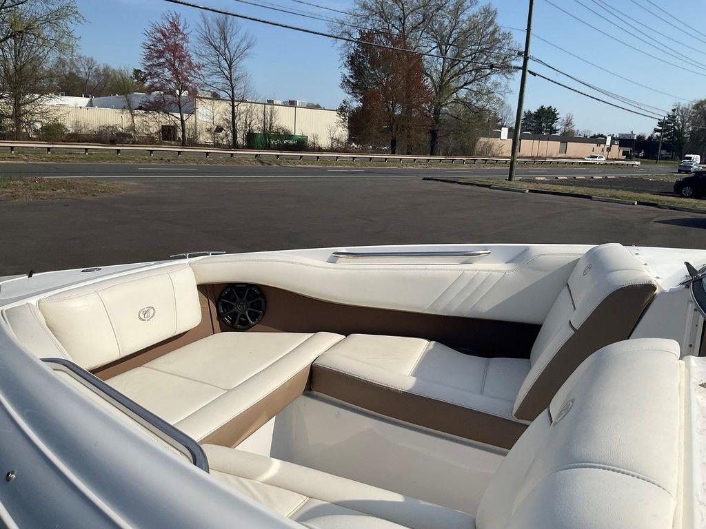 2013 Cobalt 210 boat interior with white seating and brown accents, parked outdoors.