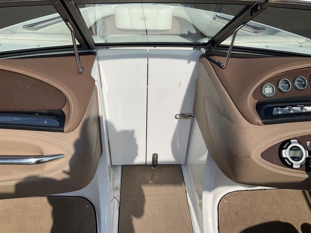Interior view of a 2013 Cobalt 210 boat cockpit with brown and beige accents.