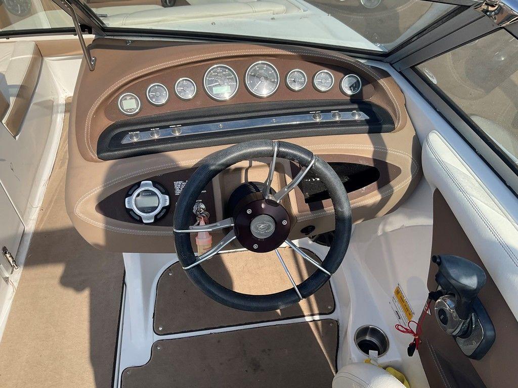 Steering wheel and dashboard of a 2013 Cobalt 210 boat, featuring multiple gauges.