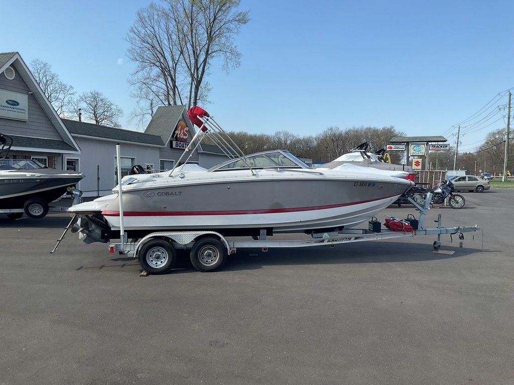 2013 Cobalt 210 boat on trailer in parking lot, clear sky background.