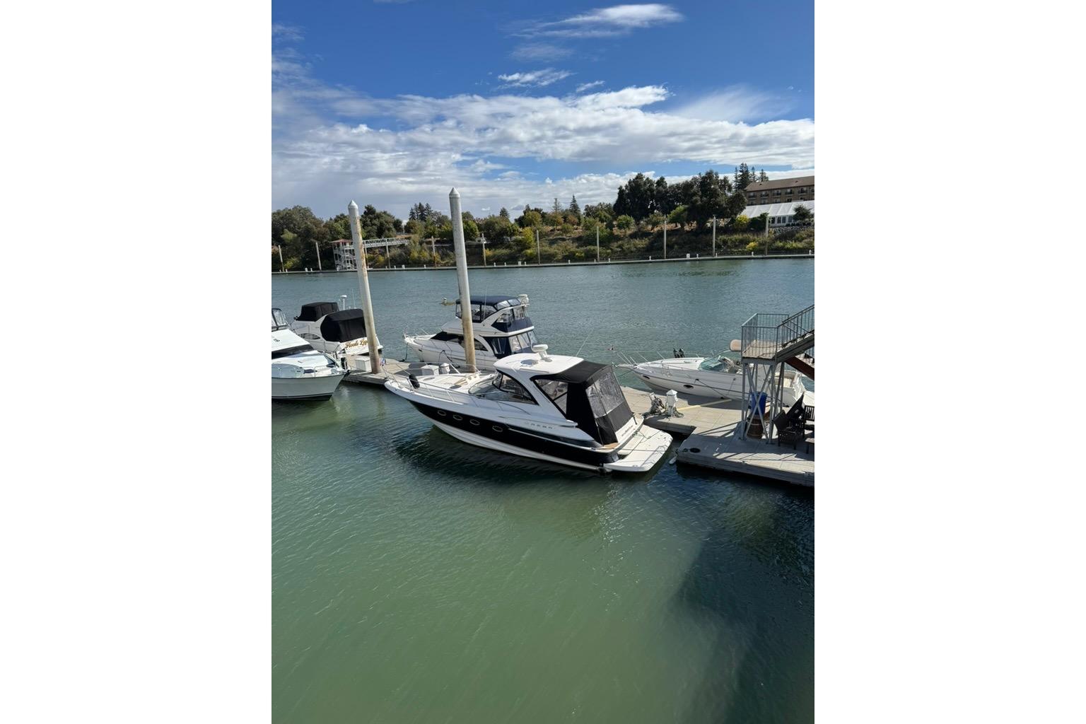 2006 Regal Commodore 4460 yacht docked at a marina under a clear blue sky.