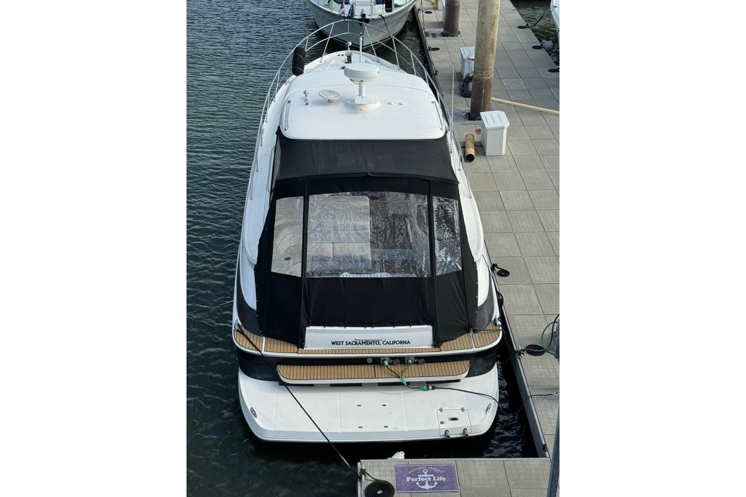 2006 Regal Commodore 4460 yacht docked at marina, rear view with black canopy.