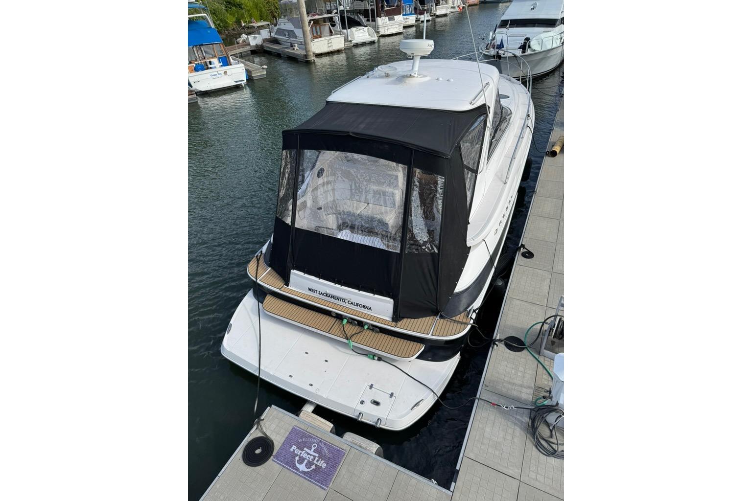 2006 Regal Commodore 4460 yacht docked at marina, featuring black canopy and sleek design.