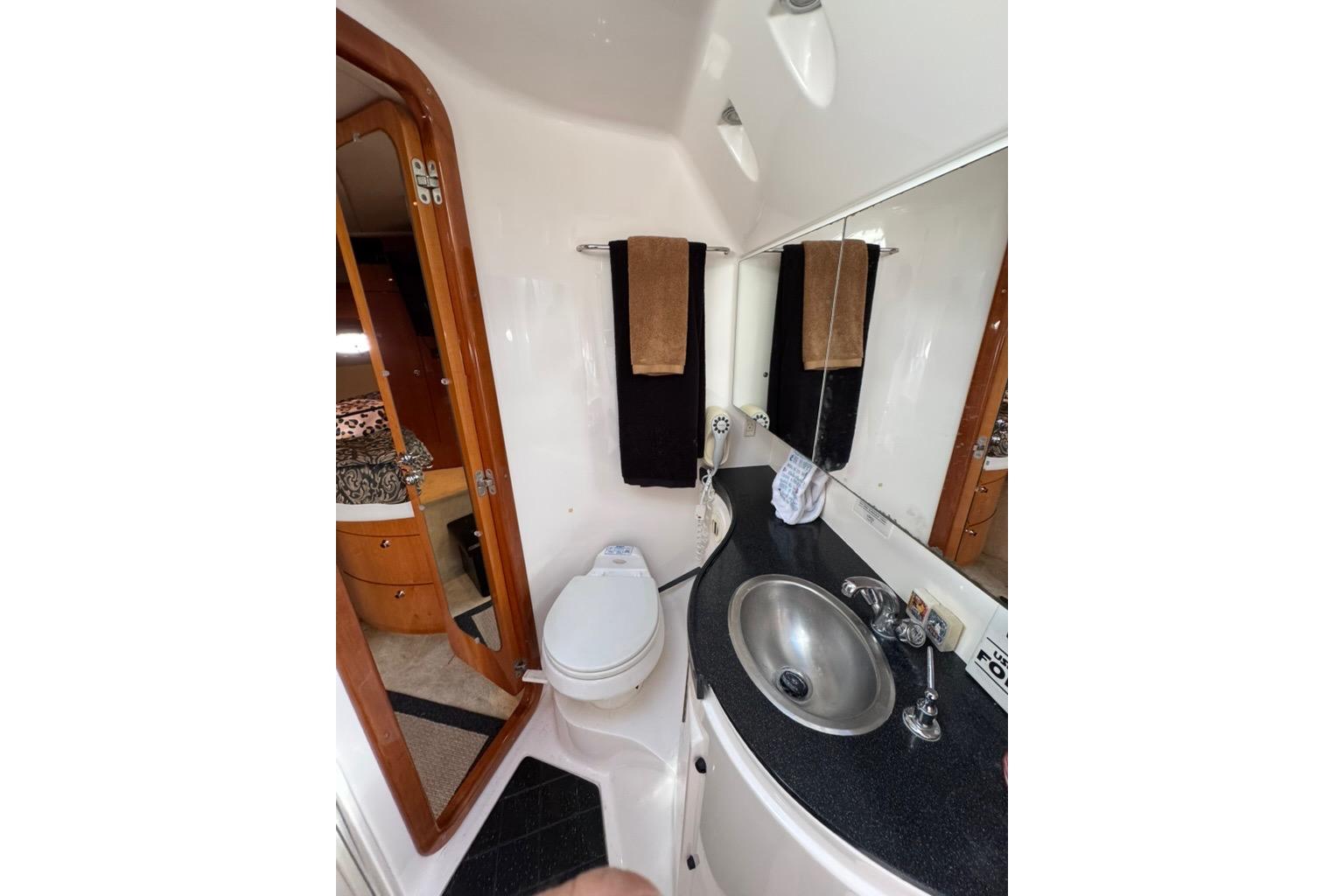 2006 Regal Commodore 4460 yacht bathroom with sink, toilet, and mirror.