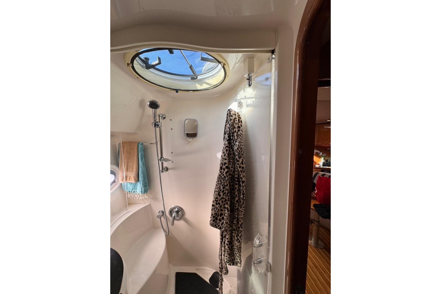 Bathroom interior of 2006 Regal Commodore 4460 yacht with shower and porthole.