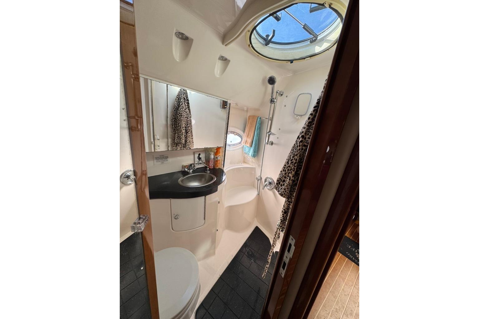 2006 Regal Commodore 4460 yacht bathroom with sink, shower, and porthole window.