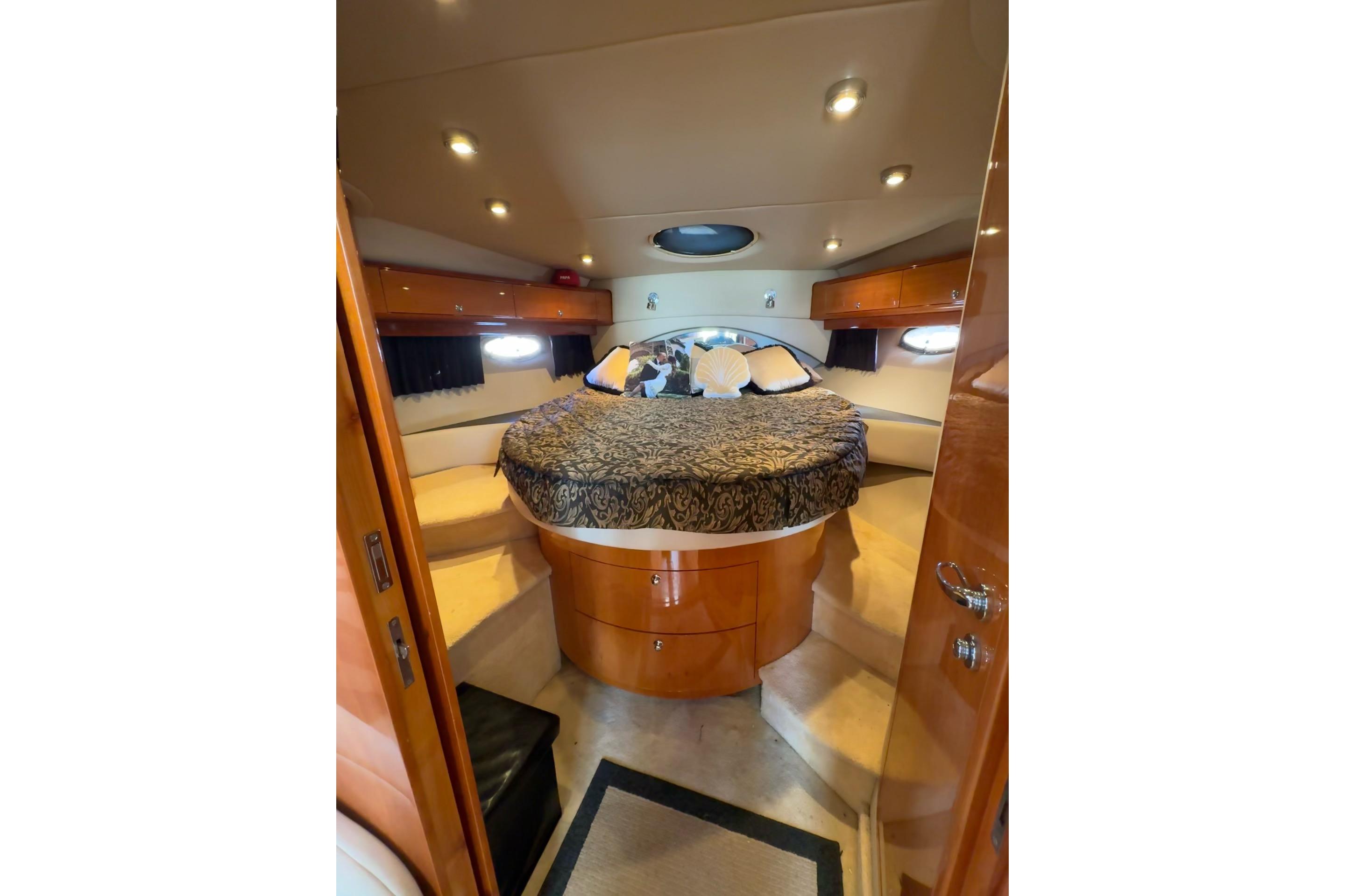 Luxurious 2006 Regal Commodore 4460 yacht interior with elegant bedding and ambient lighting.