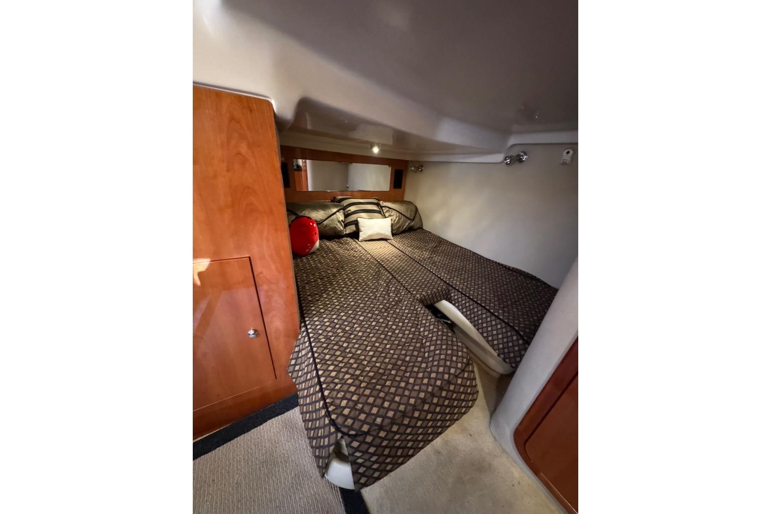 Luxurious cabin interior of 2006 Regal Commodore 4460 yacht with cozy bedding.