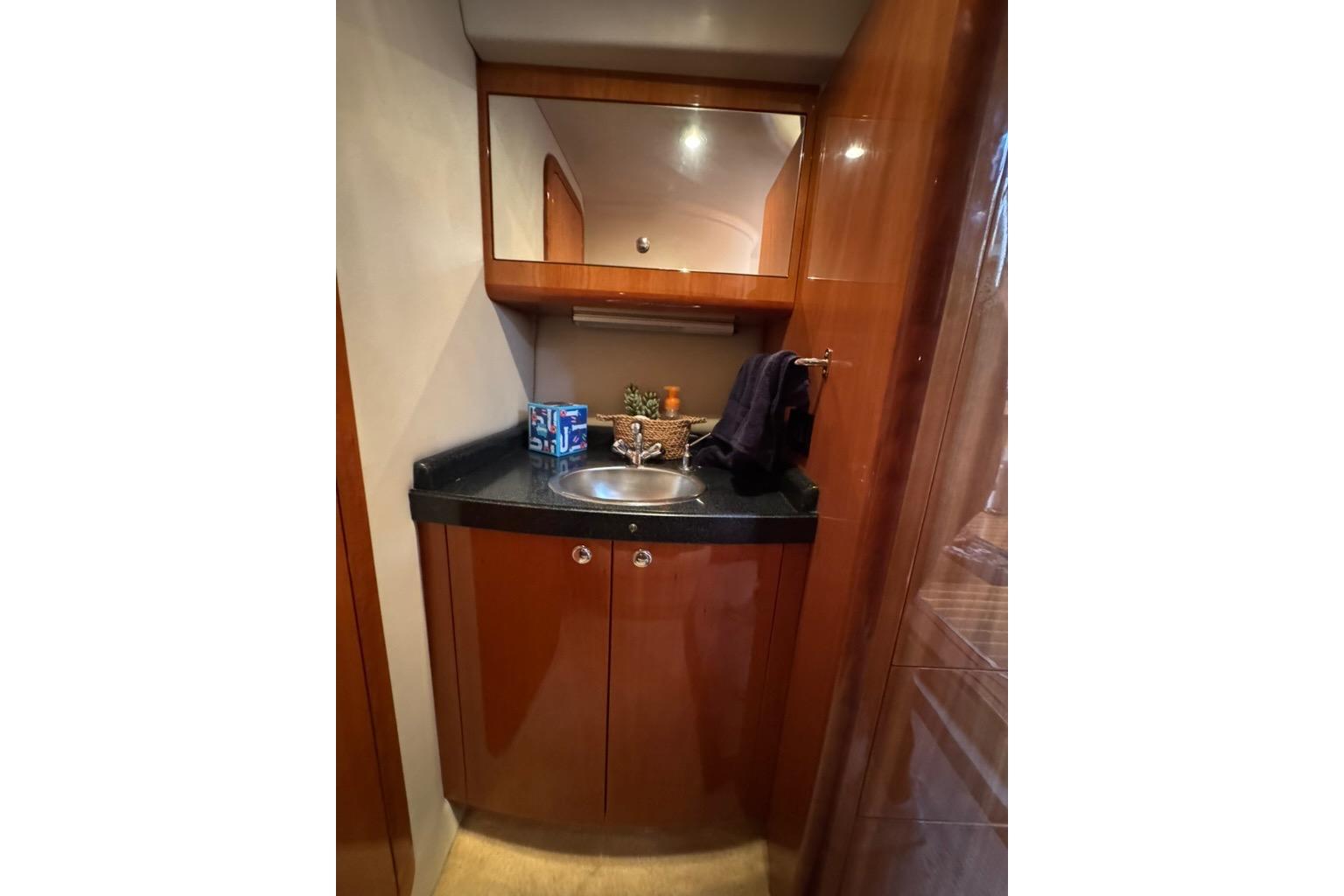 2006 Regal Commodore 4460 yacht bathroom with wooden cabinetry and sleek sink design.