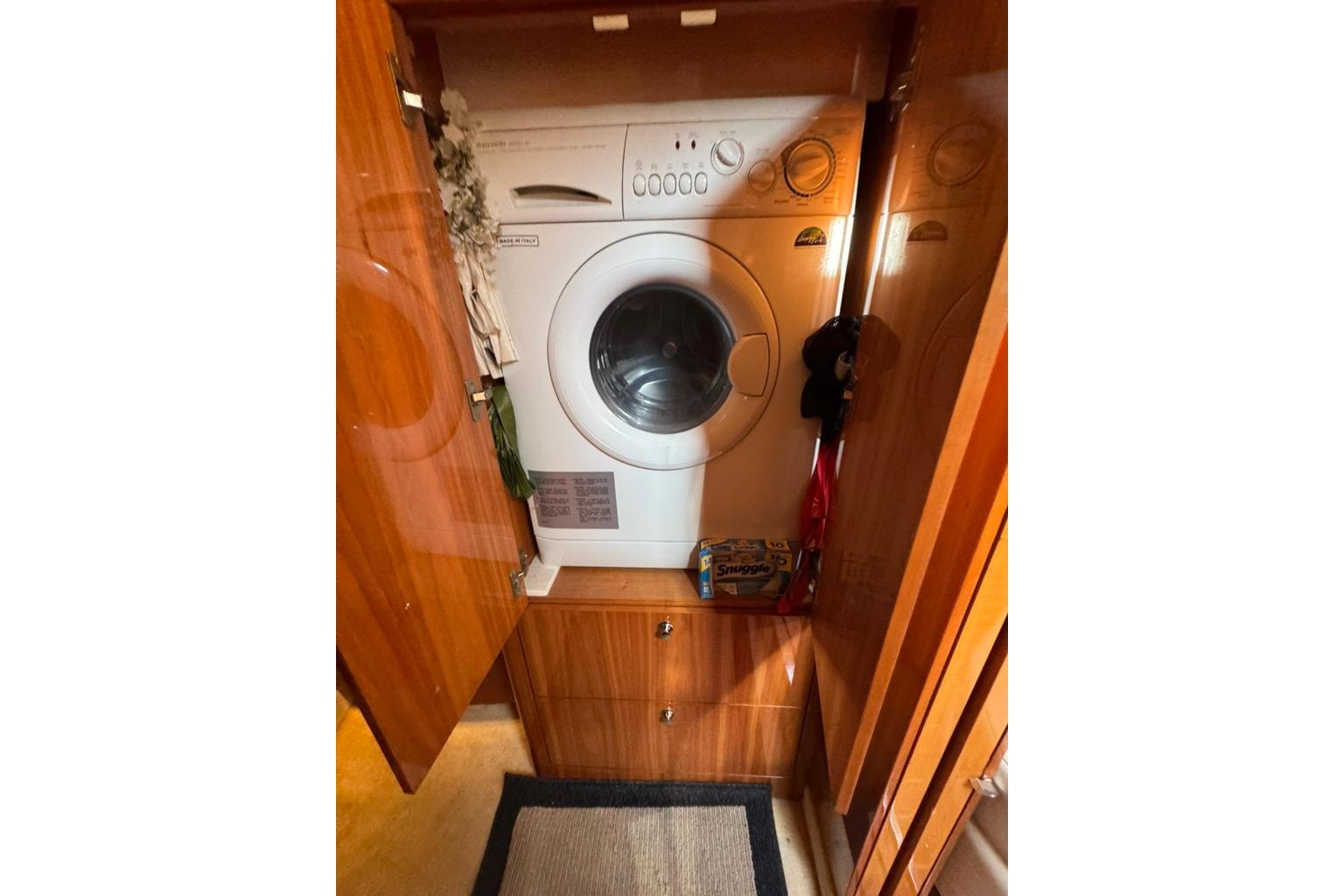 Laundry area inside 2006 Regal Commodore 4460 yacht with washing machine and storage.