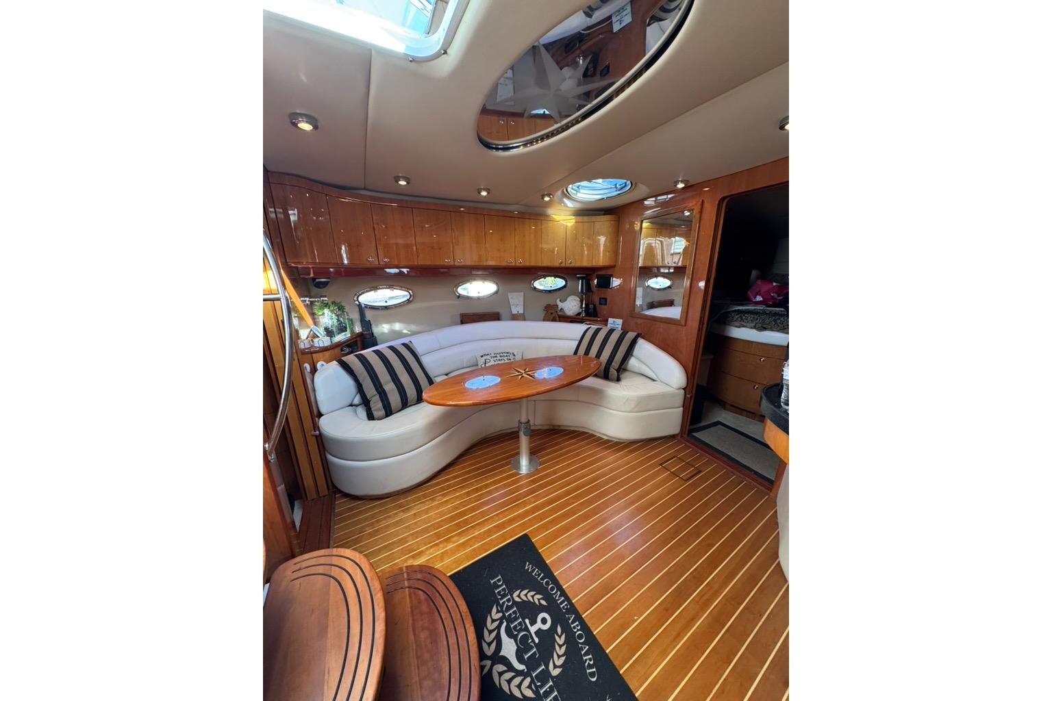 Luxurious interior of 2006 Regal Commodore 4460 yacht with elegant seating and wooden flooring.