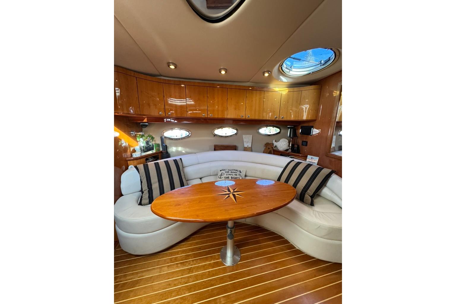 Luxurious interior of 2006 Regal Commodore 4460 yacht with elegant seating and wooden table.