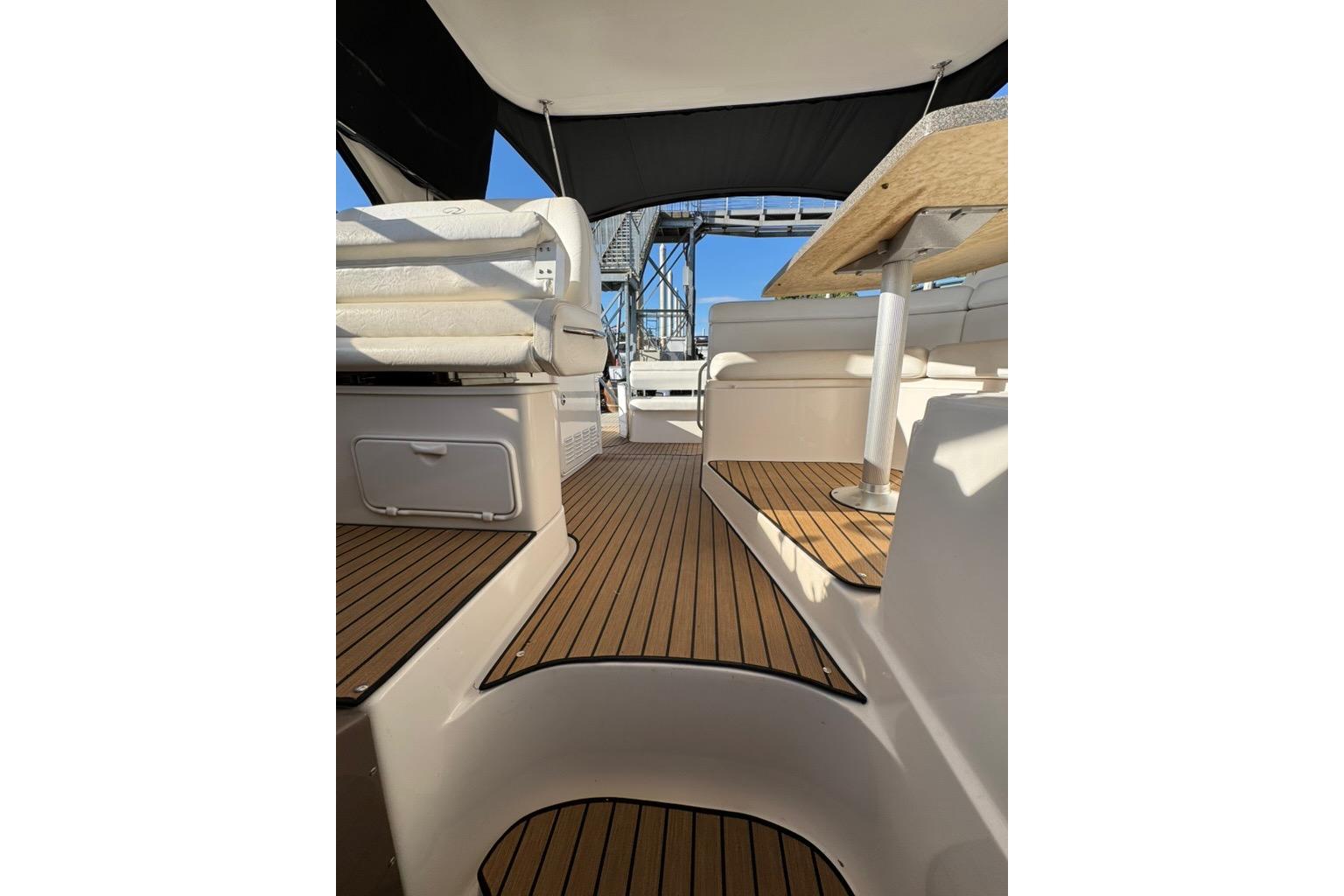 2006 Regal Commodore 4460 yacht interior with wooden flooring and seating area.