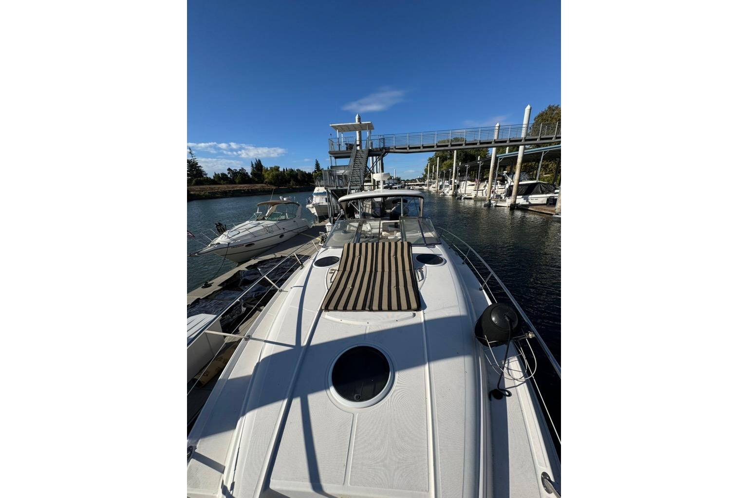 2006 Regal Commodore 4460 yacht docked at marina under clear blue sky.