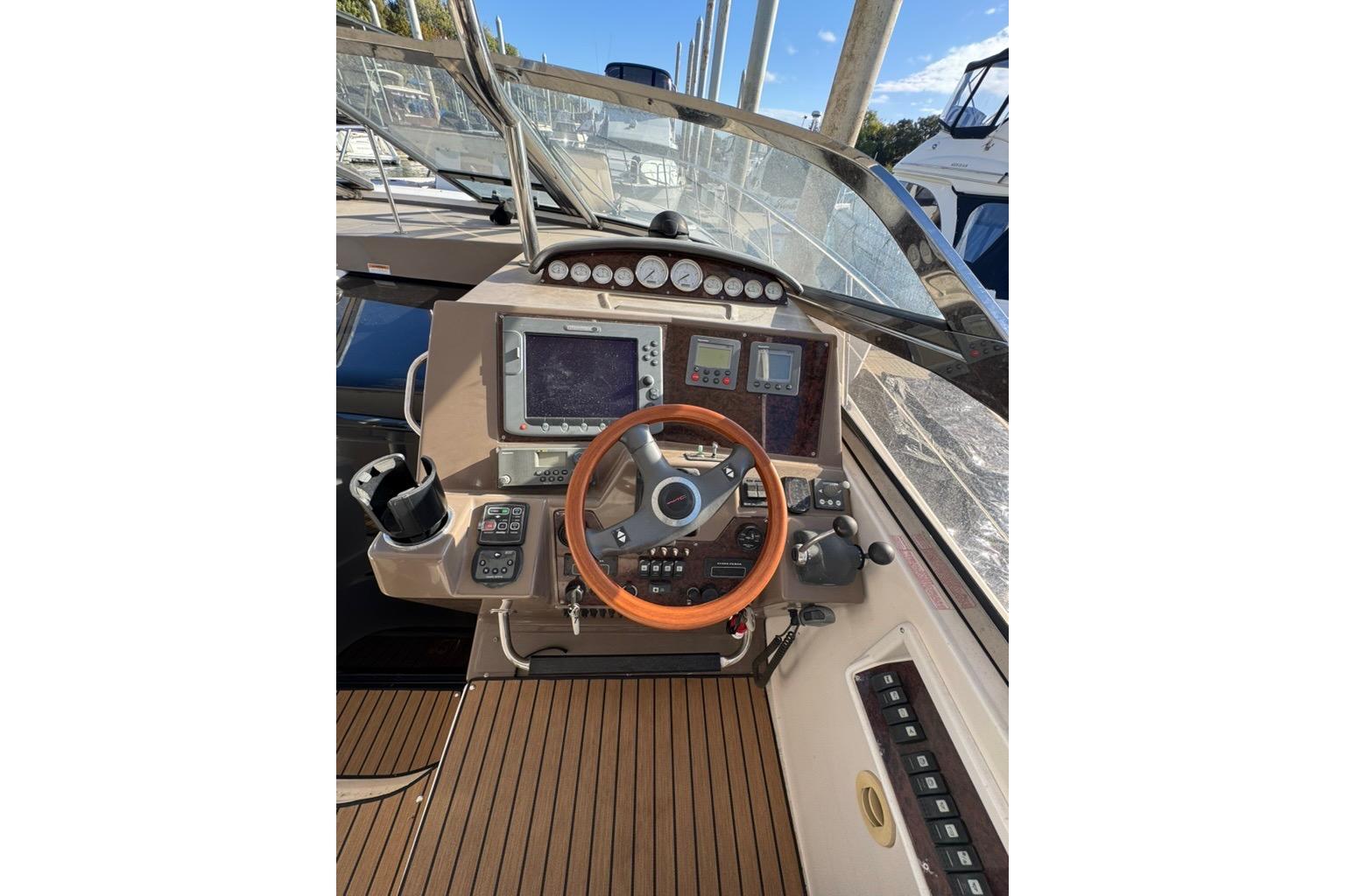 2006 Regal Commodore 4460 helm with wooden steering wheel and navigation instruments.