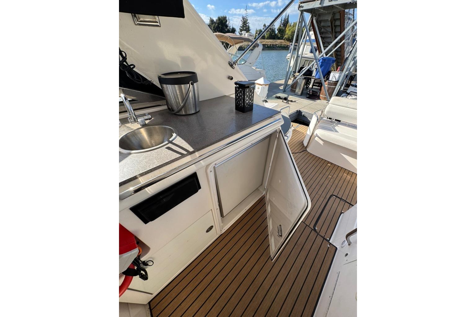 2006 Regal Commodore 4460 yacht with open cabinet and sink on deck.