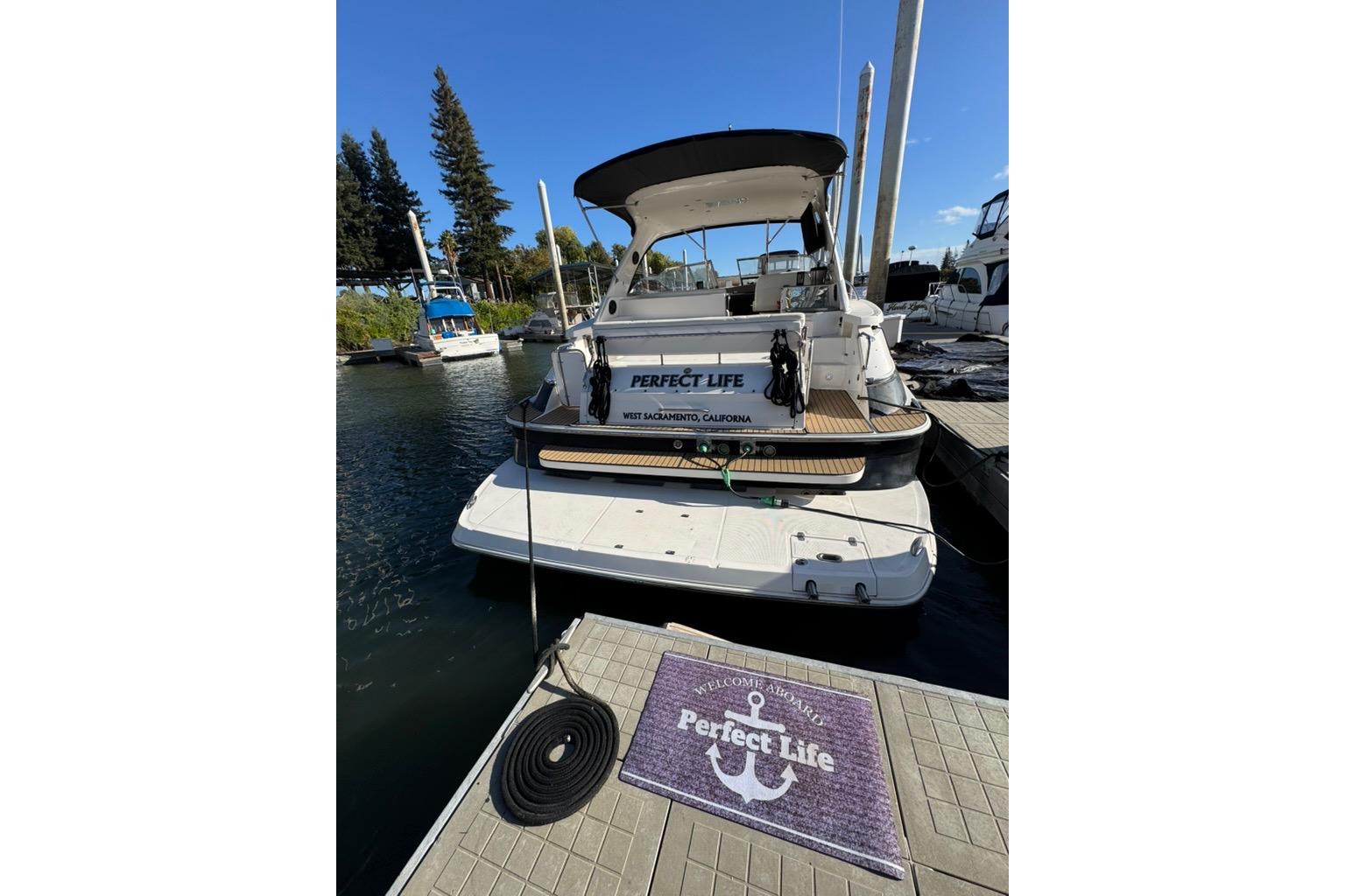 2006 Regal Commodore 4460 yacht docked, featuring "Perfect Life" signage and welcome mat.