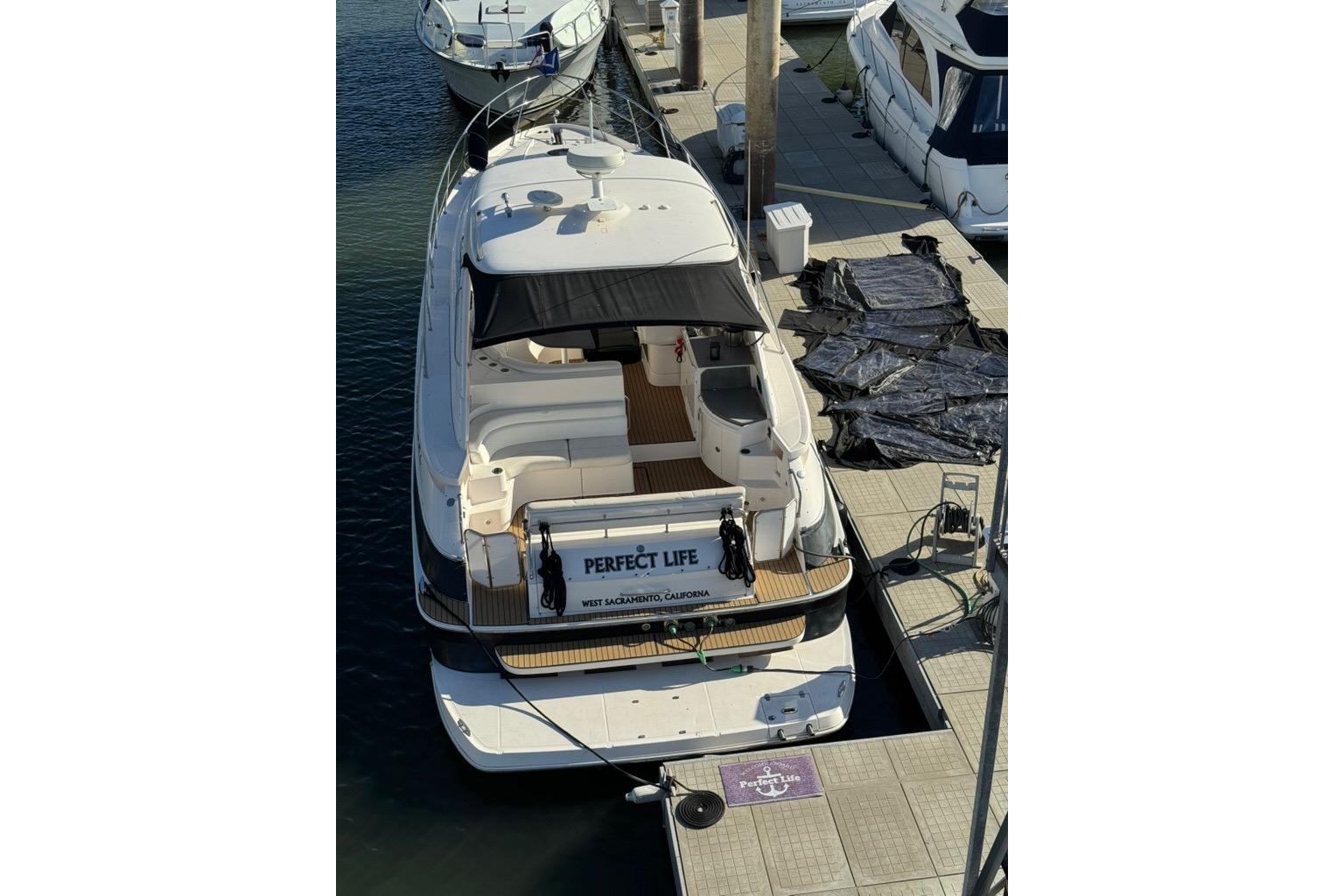 2006 Regal Commodore 4460 yacht docked at marina, featuring spacious deck and canopy.