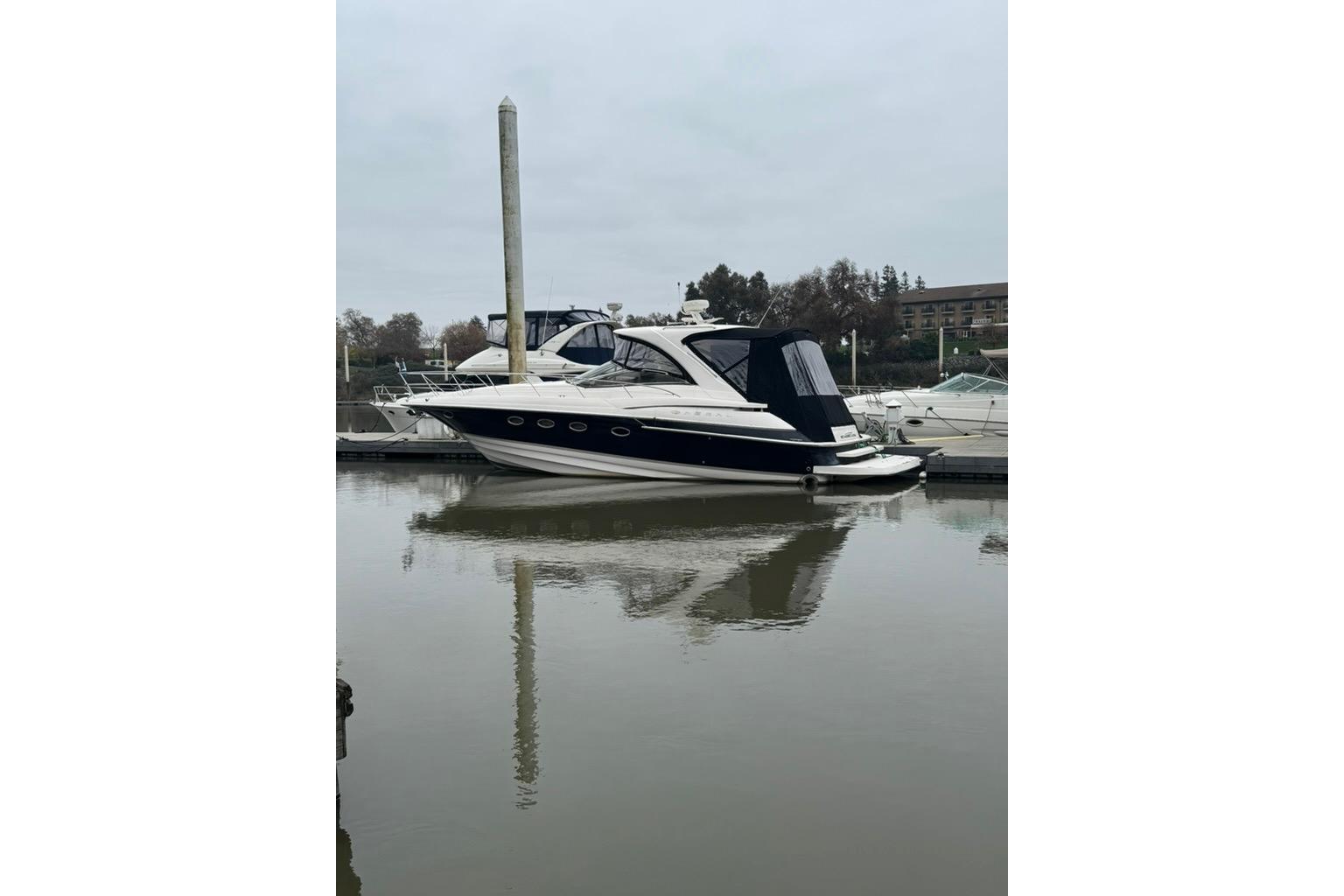 2006 Regal Commodore 4460 yacht docked in a marina, reflecting on calm water.