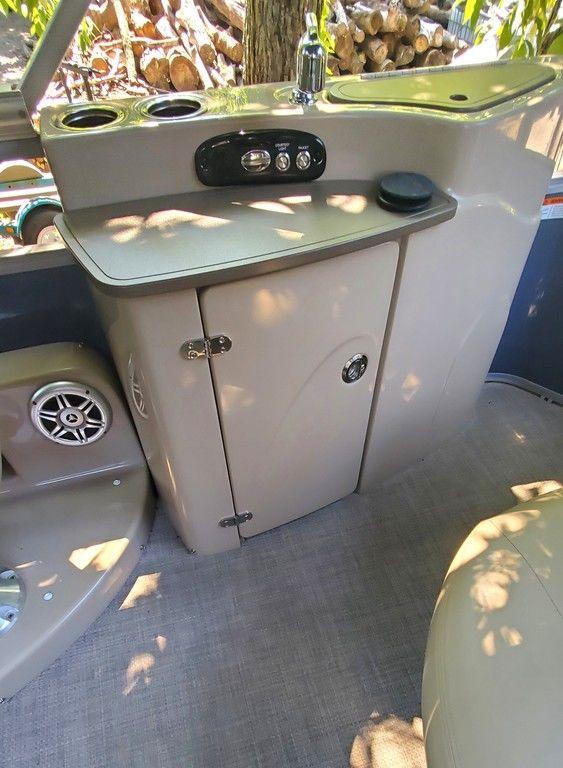 2017 Regency 220 DL3 boat interior with control panel and storage cabinet.