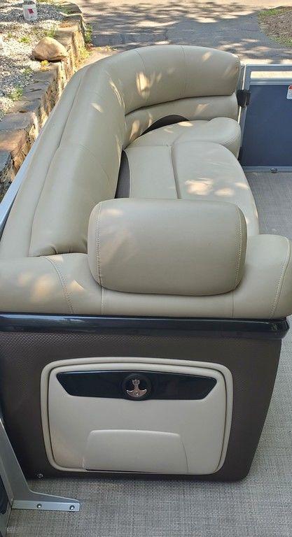 2017 Regency 220 DL3 boat with beige leather seating and storage compartment.