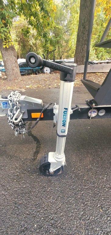 Trailer hitch and jack of a 2017 Regency 220 DL3 boat on asphalt.
