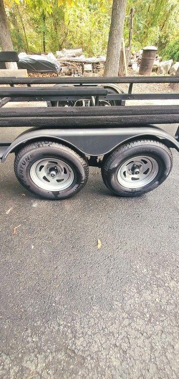 Trailer with dual wheels on asphalt, surrounded by trees. Regency 220 DL3, 2017 model.
