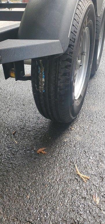 Trailer tire of a 2017 Regency 220 DL3 on asphalt pavement.