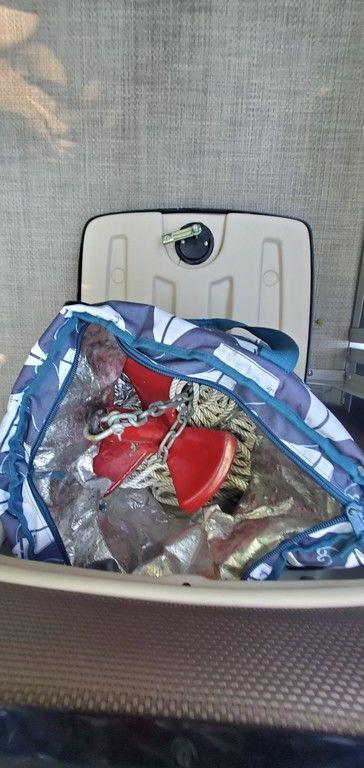 Storage compartment on a 2017 Regency 220 DL3 boat with a bag and red anchor.
