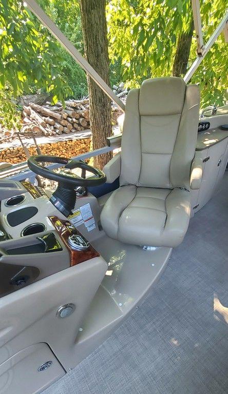 2017 Regency 220 DL3 boat interior with beige captain's chair and steering wheel.