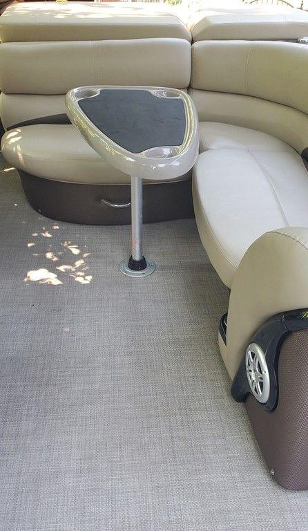 2017 Regency 220 DL3 boat interior with beige seating and a central table.