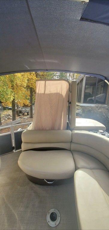 2017 Regency 220 DL3 pontoon boat interior with beige seating and canopy.