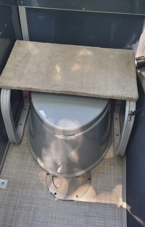 2017 Regency 220 DL3 boat toilet with cushioned lid in compact enclosure.