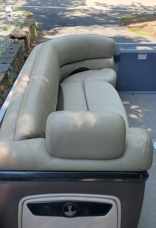 2017 Regency 220 DL3 boat with beige leather seating, parked outdoors.