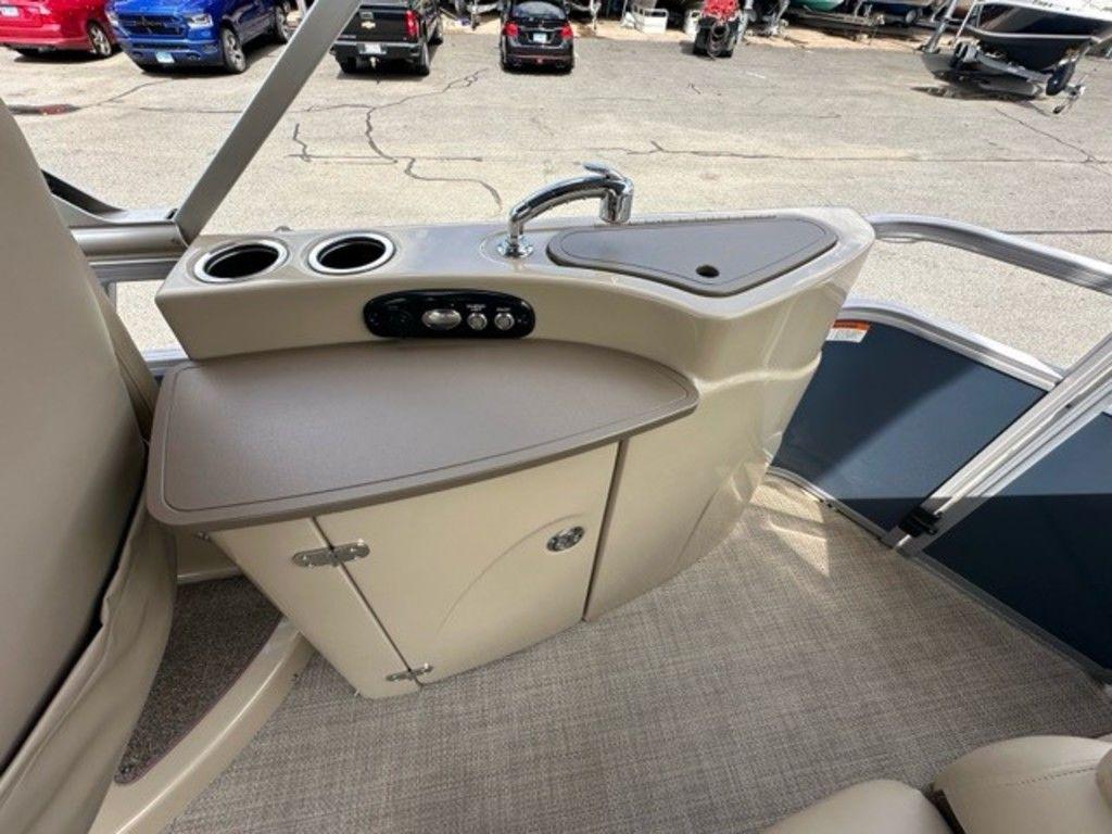 2017 Regency 220 DL3 boat interior with sink and storage cabinet.