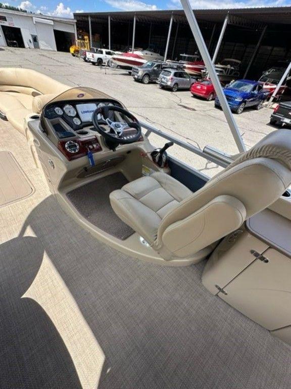 2017 Regency 220 DL3 boat interior with steering console and beige seating.