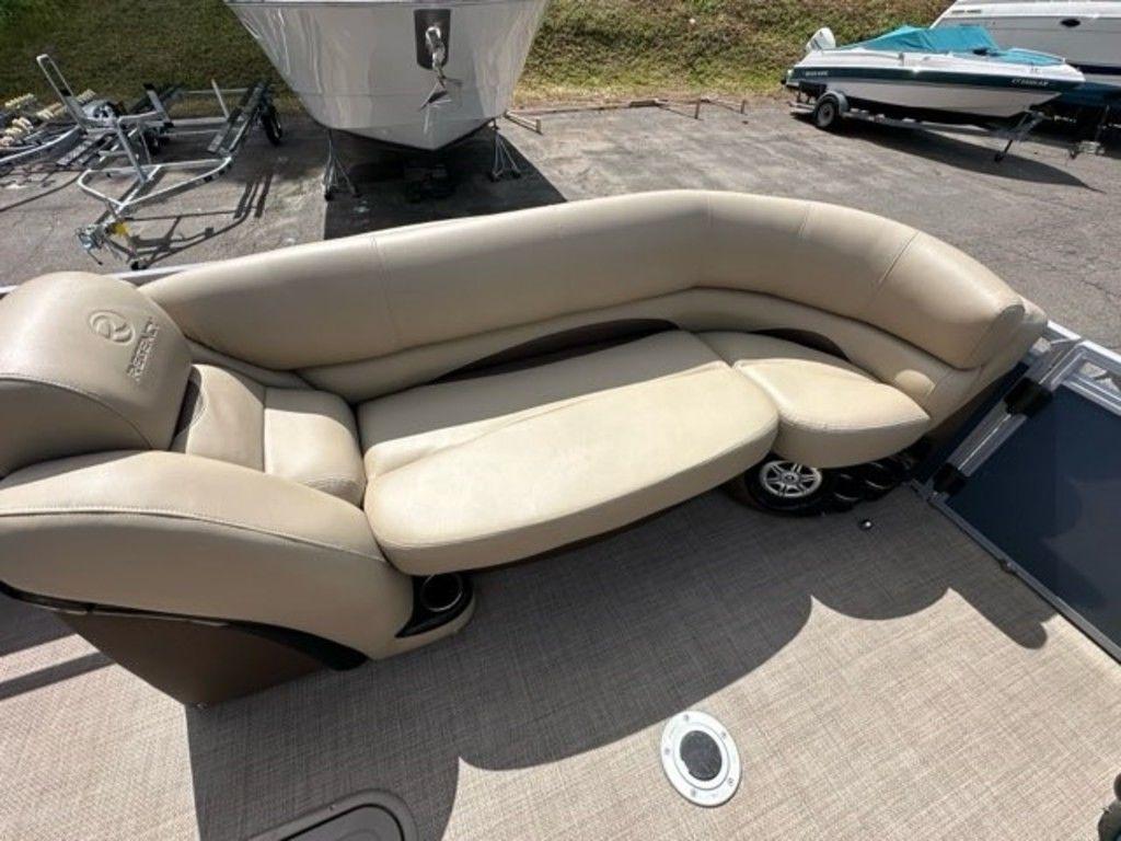 2017 Regency 220 DL3 boat with beige seating, docked on a sunny day.
