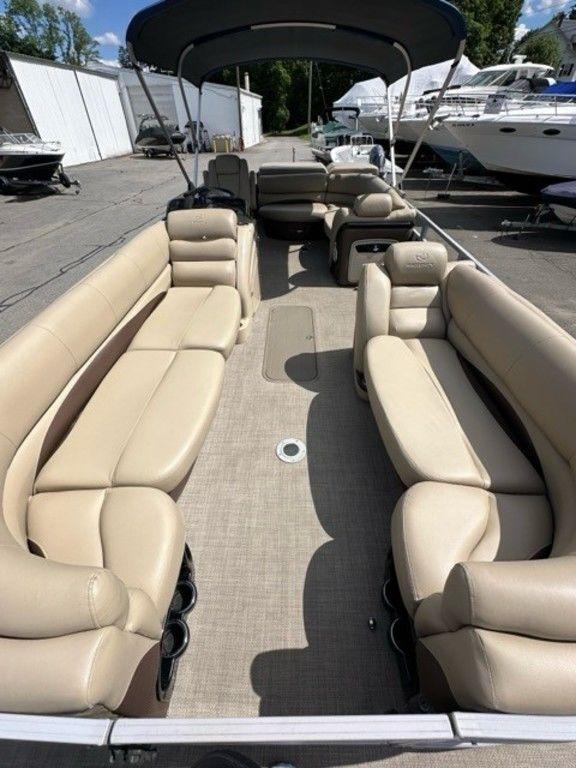 2017 Regency 220 DL3 pontoon boat with beige seating and canopy, docked outdoors.
