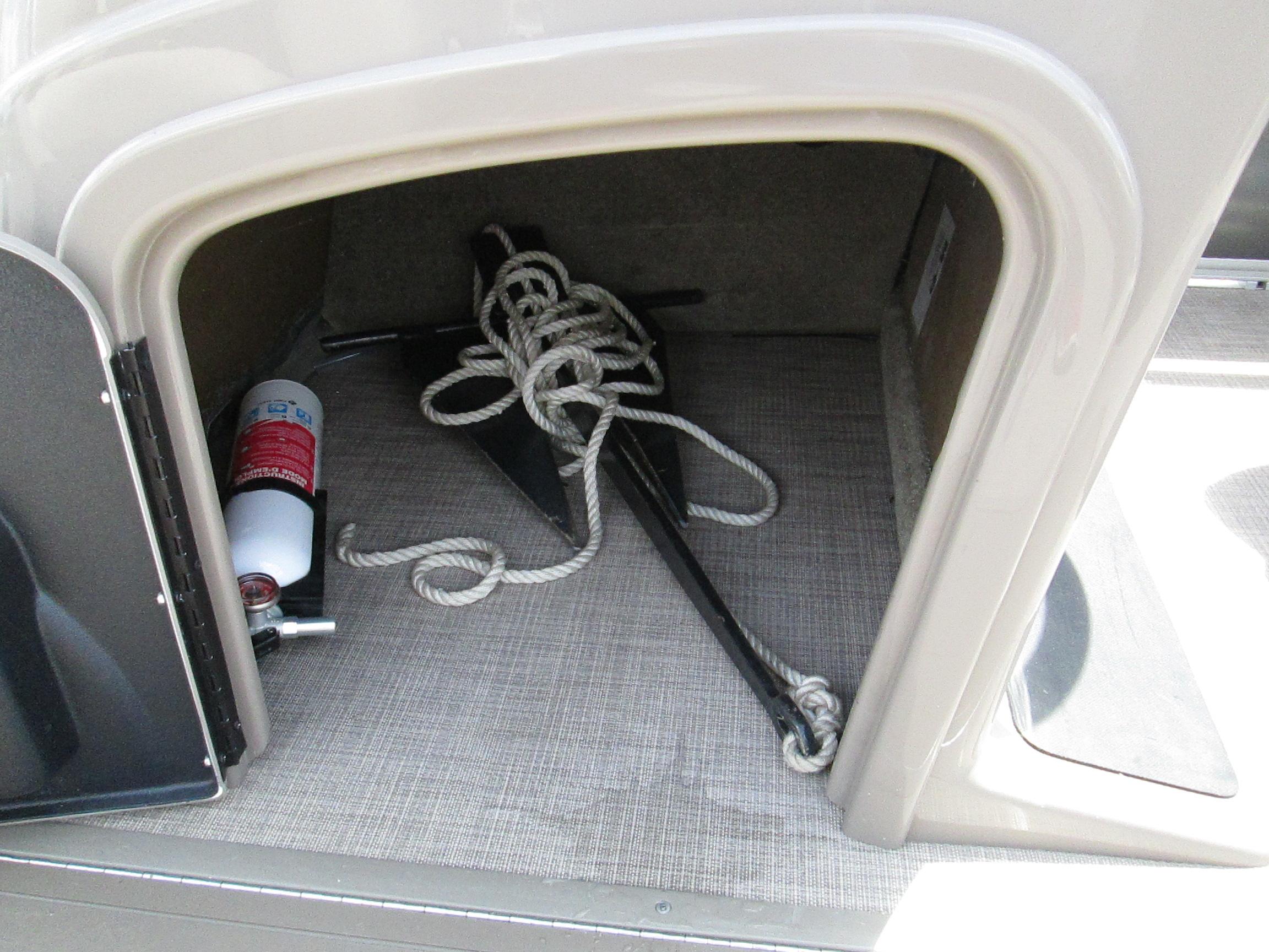 Storage compartment in 2023 Sun Tracker PARTY BARGE 22RF XP3 with anchor and fire extinguisher.