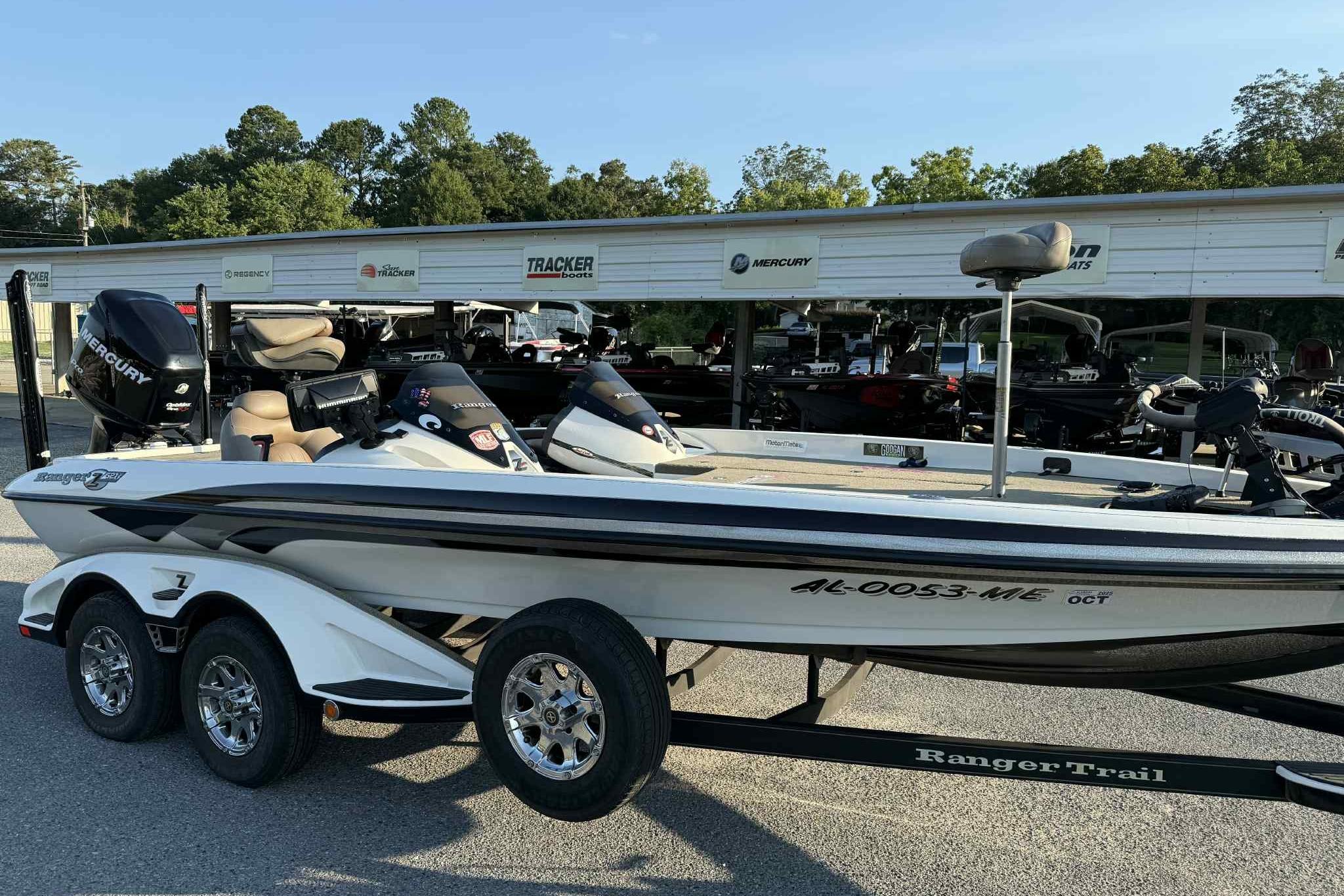 2012 Ranger Z521 Comanche boat with Mercury engine on trailer, parked outdoors.