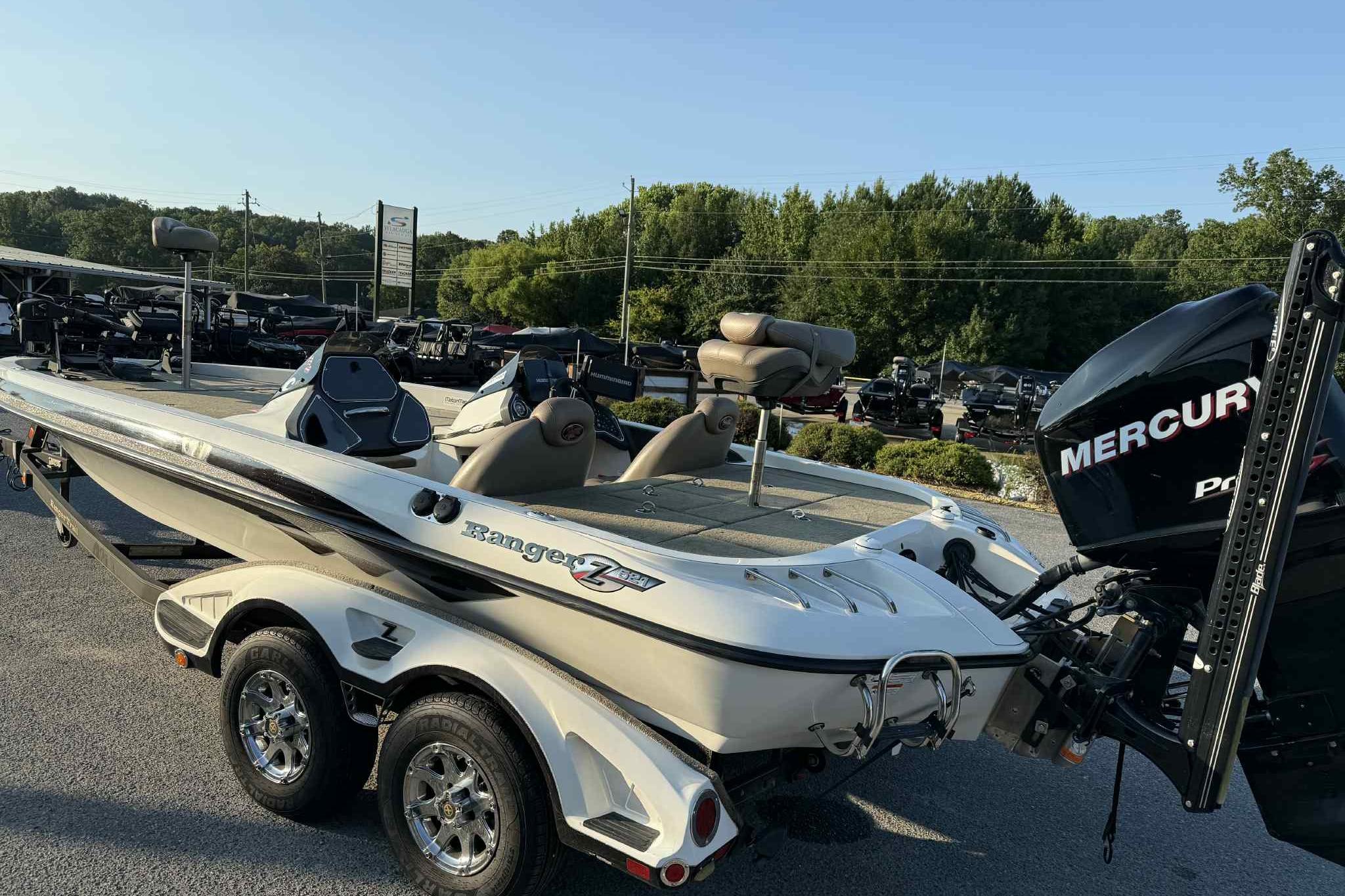2012 Ranger Z521 Comanche boat with Mercury engine on a trailer, parked outdoors.