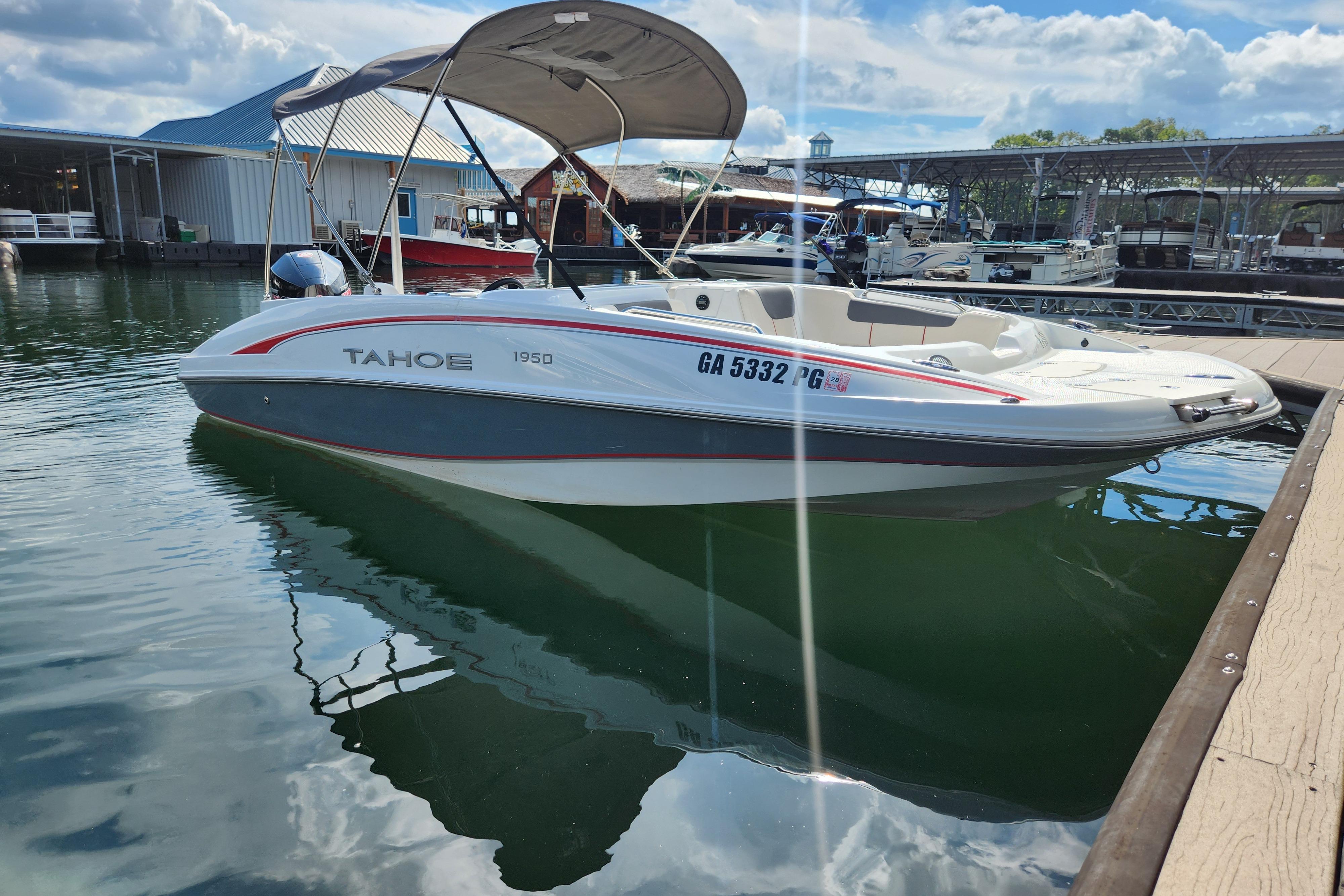 2021 Tahoe 1950 boat docked at marina under blue sky.