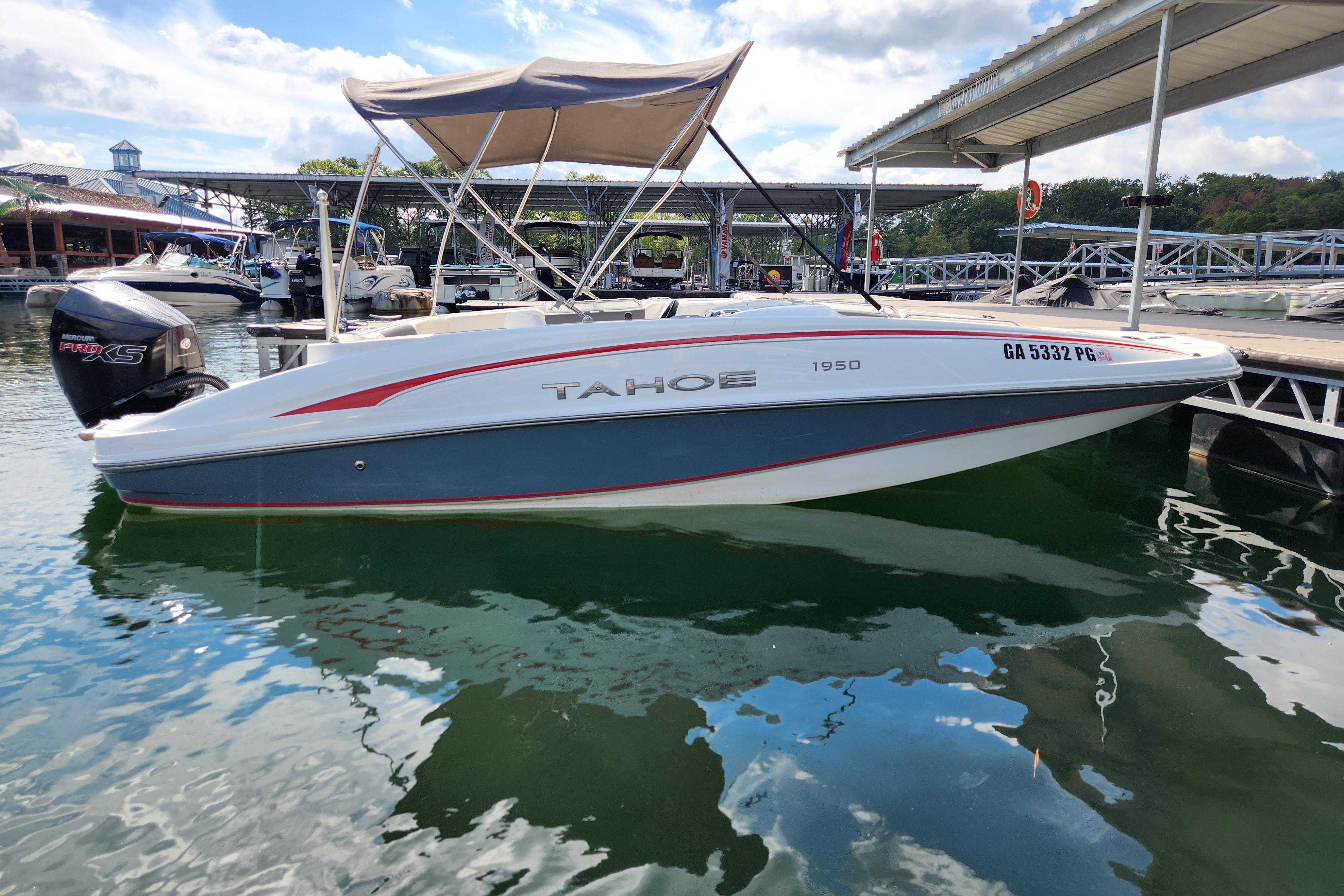 2021 Tahoe 1950 boat docked at marina, featuring sleek design and canopy.