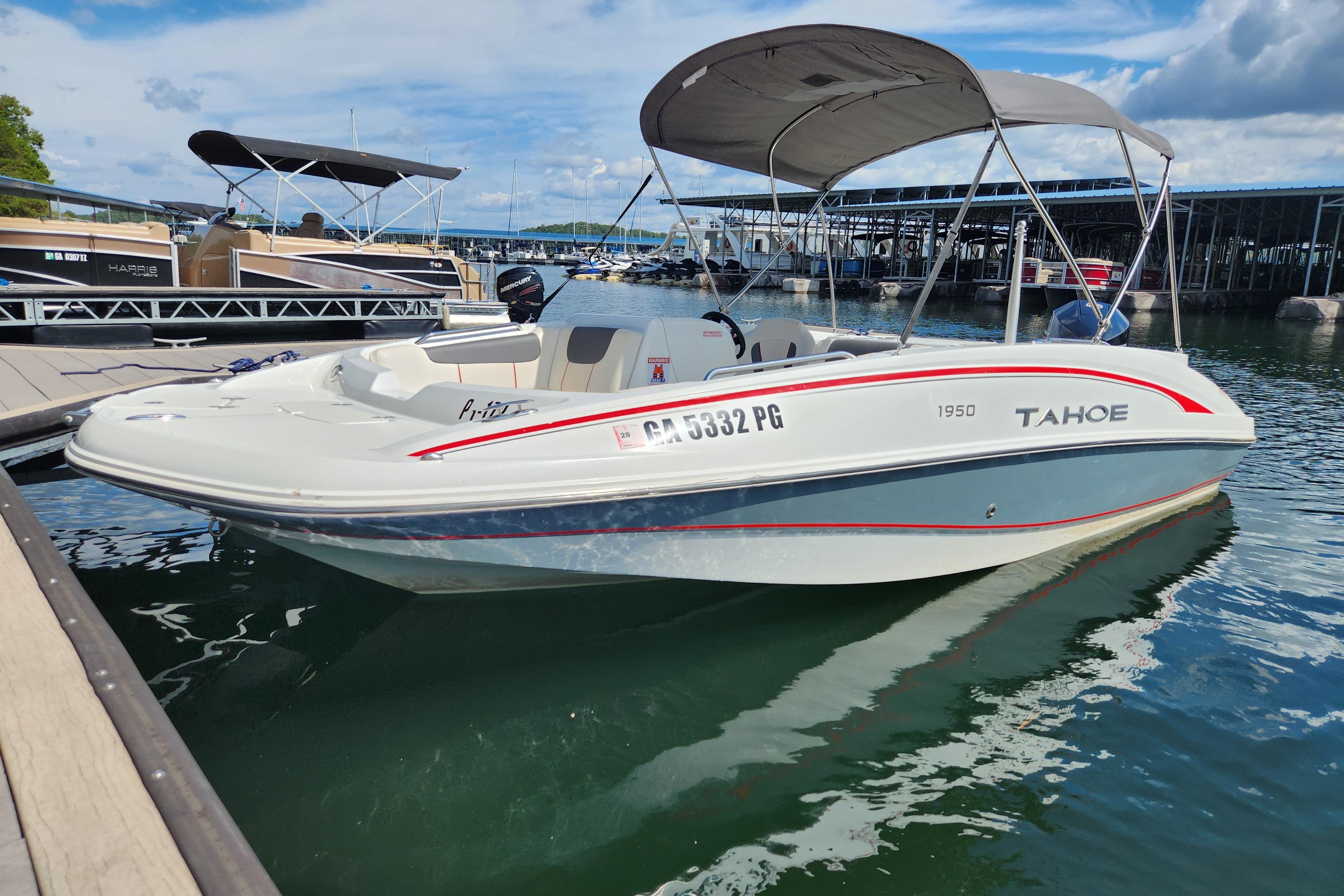 2021 Tahoe 1950 boat docked at marina, featuring canopy and sleek design.