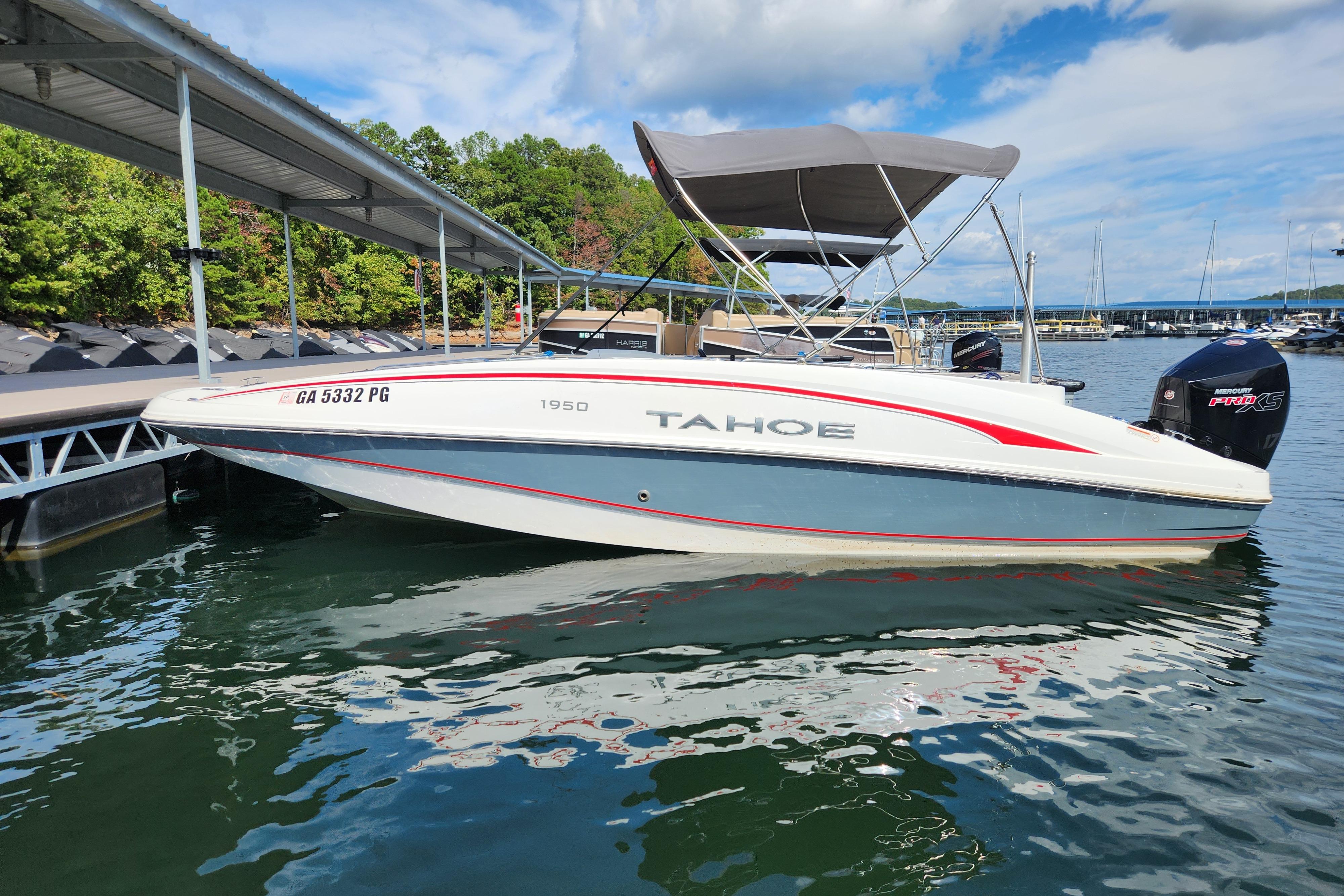 2021 Tahoe 1950 boat docked on a sunny day, featuring a sleek design and canopy.