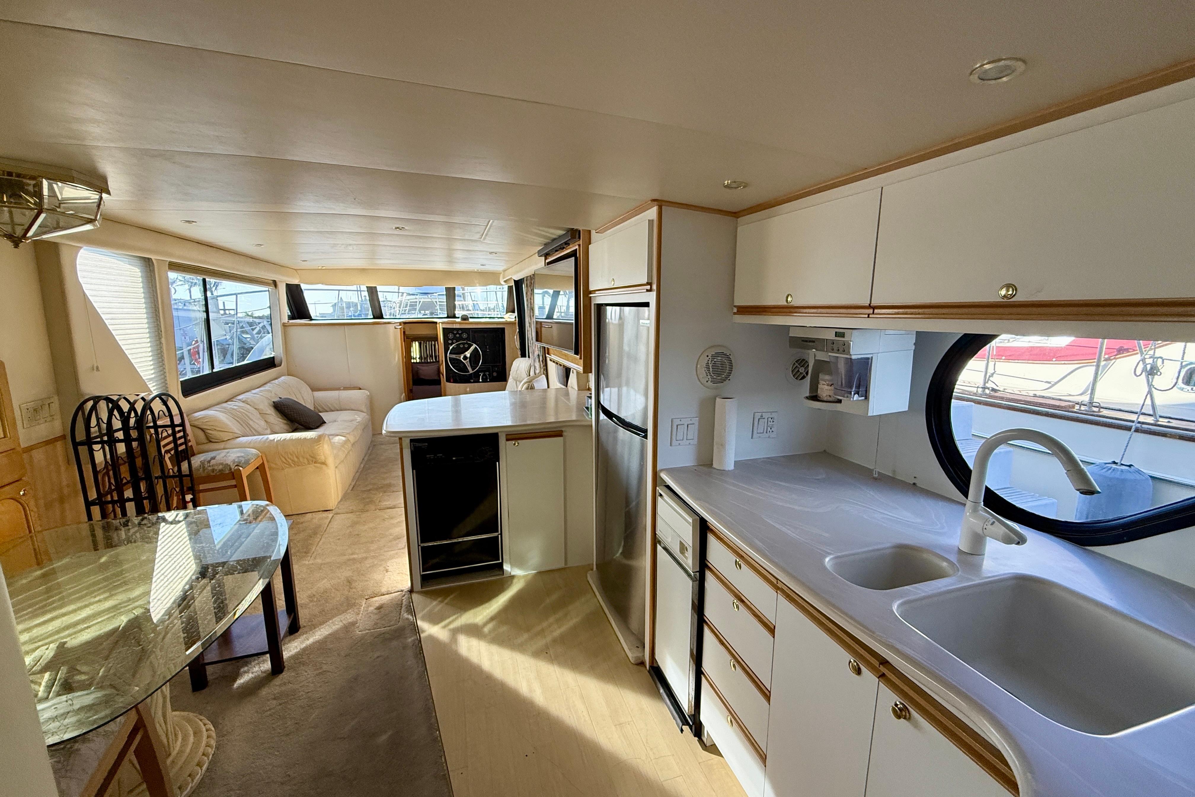Interior of 1999 Bluewater 5800 yacht with modern kitchen and spacious seating area.