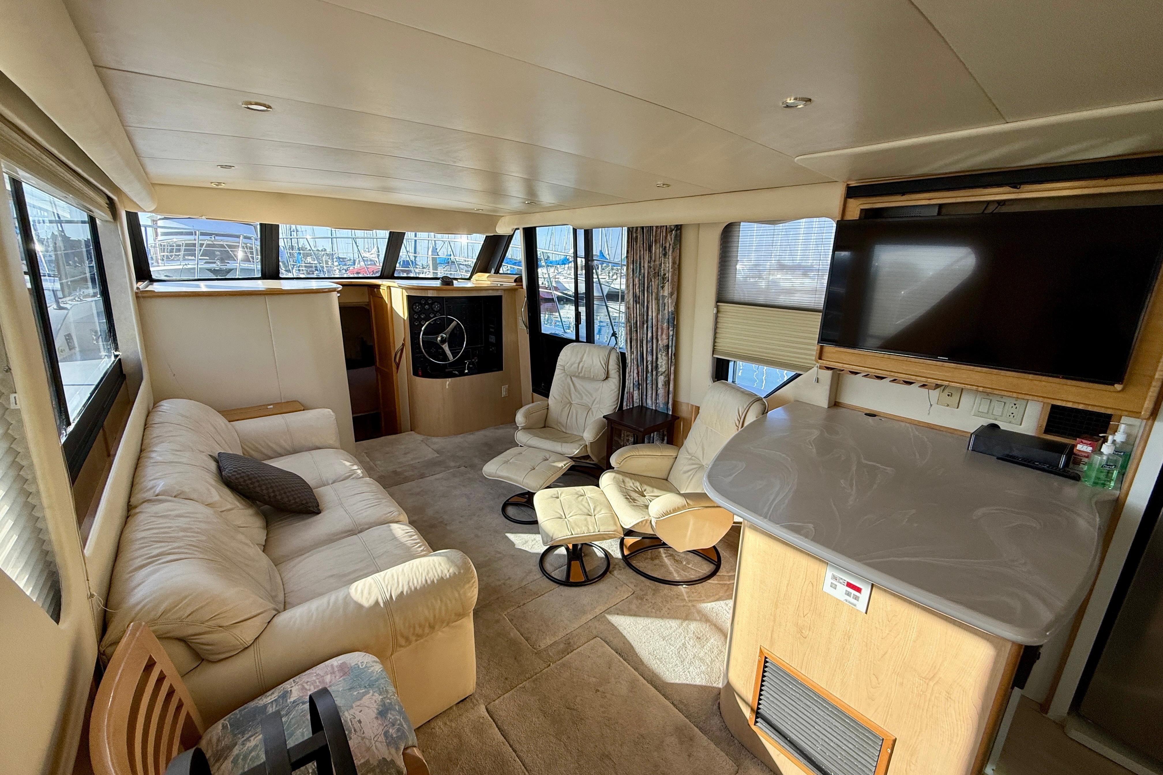 Luxurious interior of a 1999 Bluewater 5800 yacht with plush seating and modern amenities.