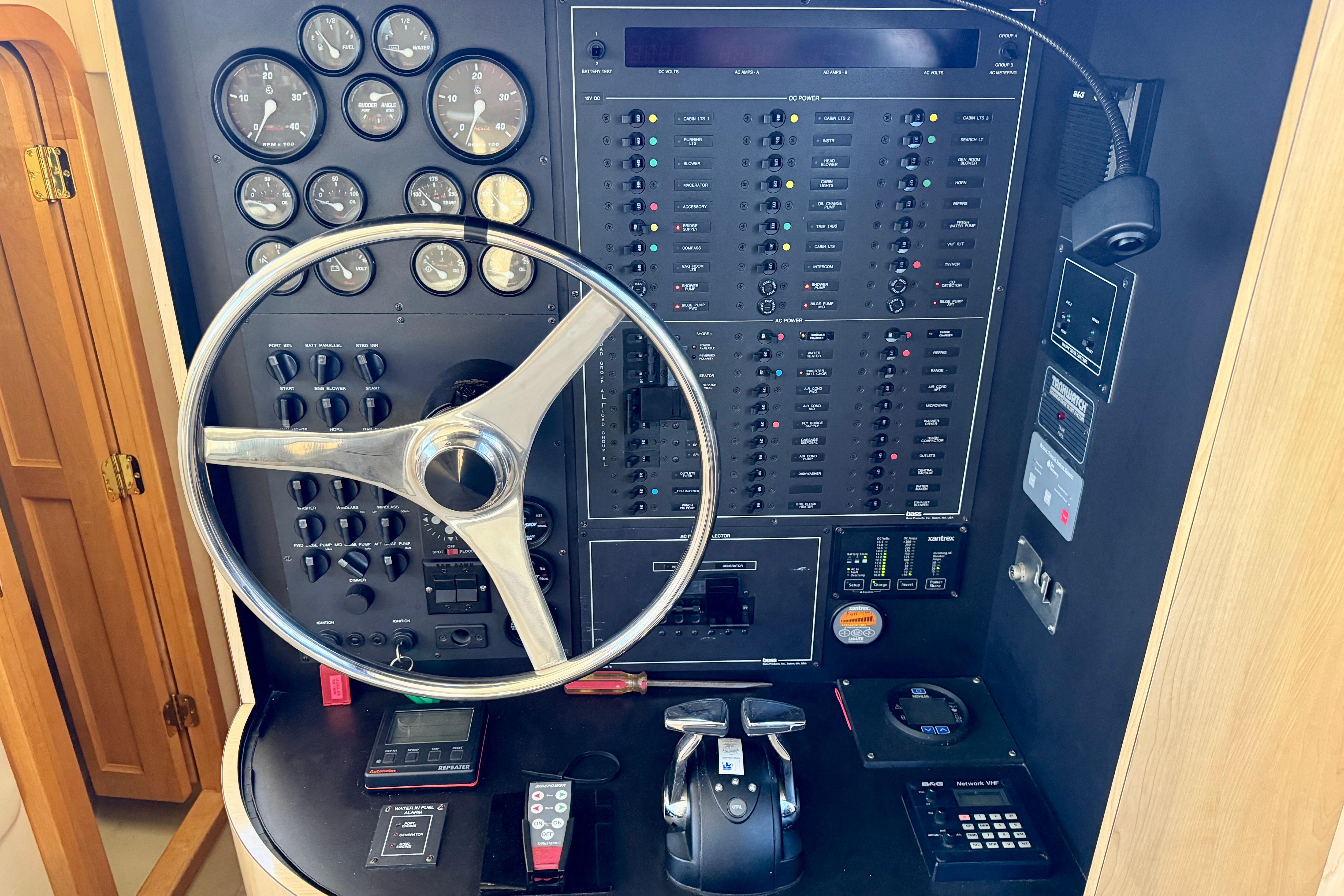 Control panel of a 1999 Bluewater 5800 yacht with steering wheel and gauges.