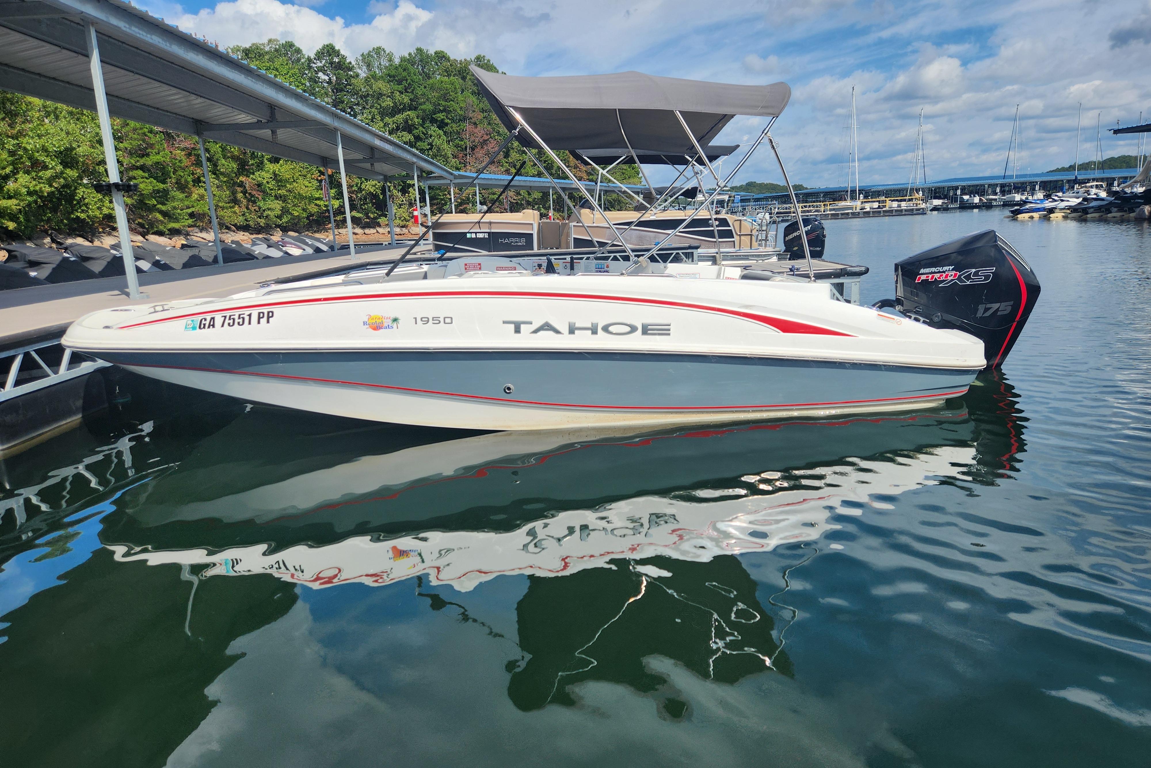 2021 Tahoe 1950 boat docked on a sunny day, featuring a sleek design and canopy.