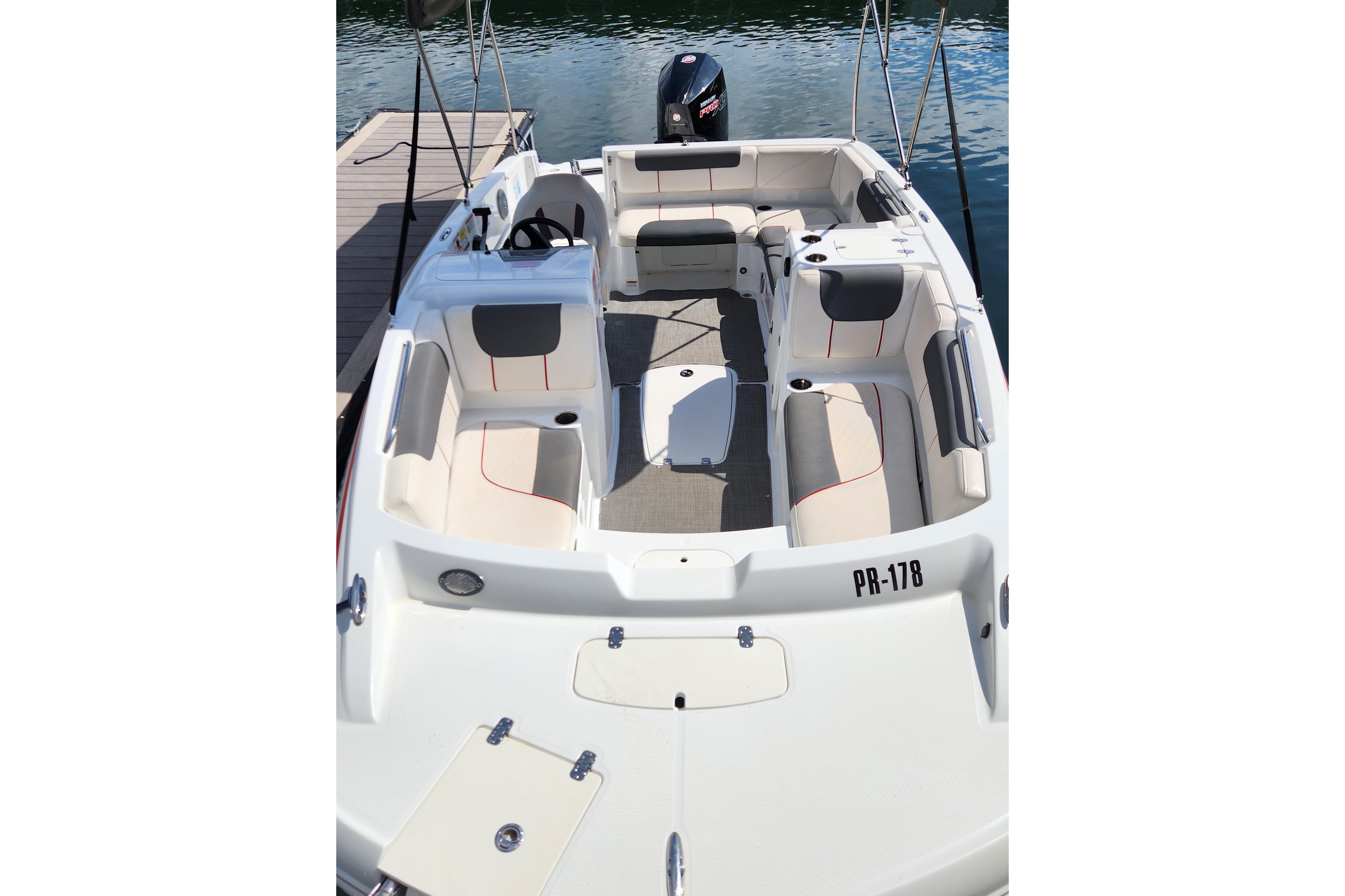 2021 Tahoe 1950 boat with spacious seating, docked on calm water.